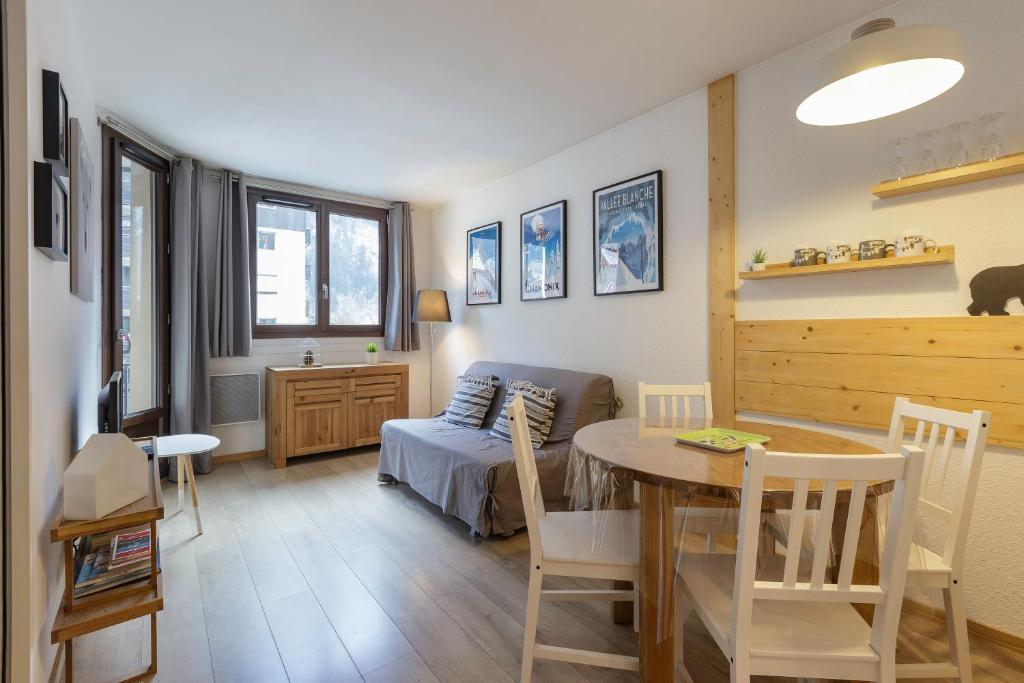 a living room with a table and a bedroom at Les Marmottes En Chaussettes - Happy Rentals in Chamonix-Mont-Blanc