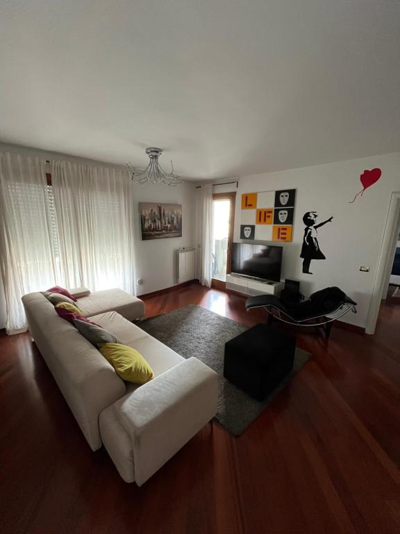 een woonkamer met een witte bank en een televisie bij Banksy in Rome