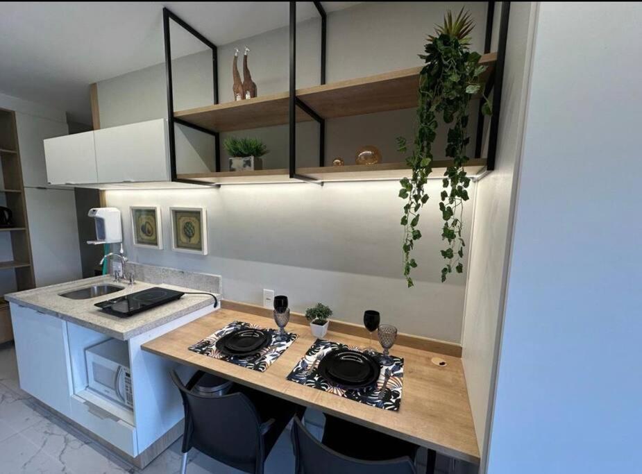 uma cozinha com um balcão com um fogão e cadeiras em Studio novo, perto Allianz Park, ao lado do metrô em São Paulo