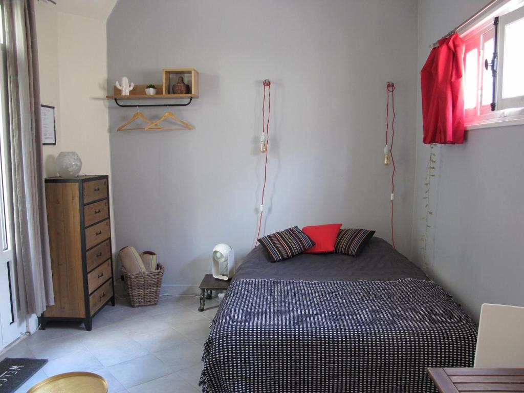 a bedroom with a black and white bed in a room at Studio avec cour extérieure aux portes de Paris in Bagnolet