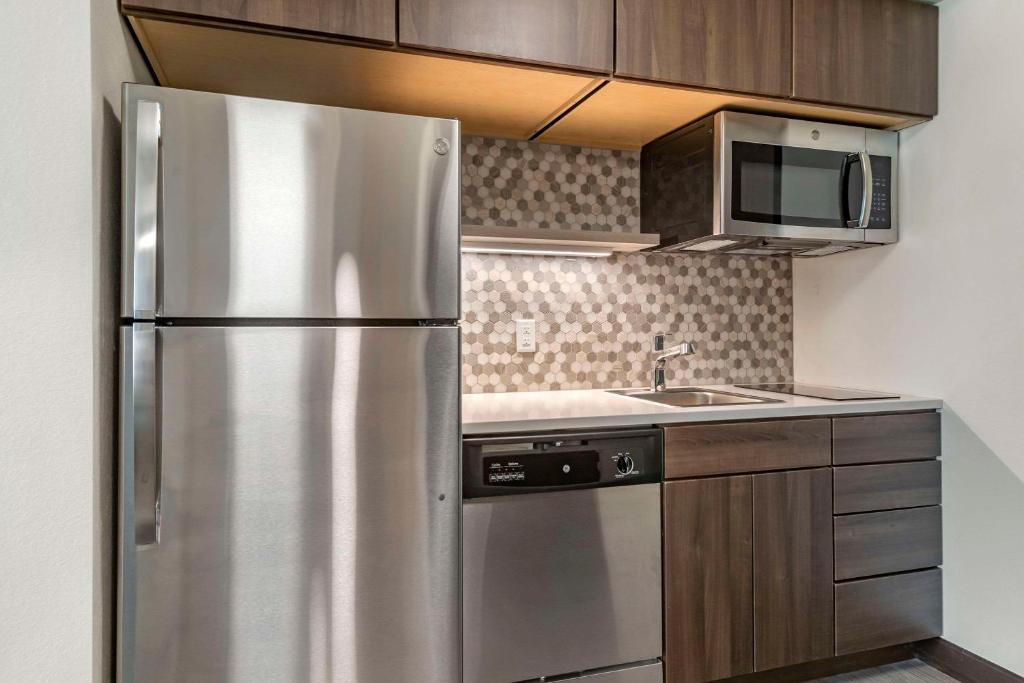 a kitchen with a stainless steel refrigerator and a sink at MainStay Suites Milwaukee-Franklin in Franklin