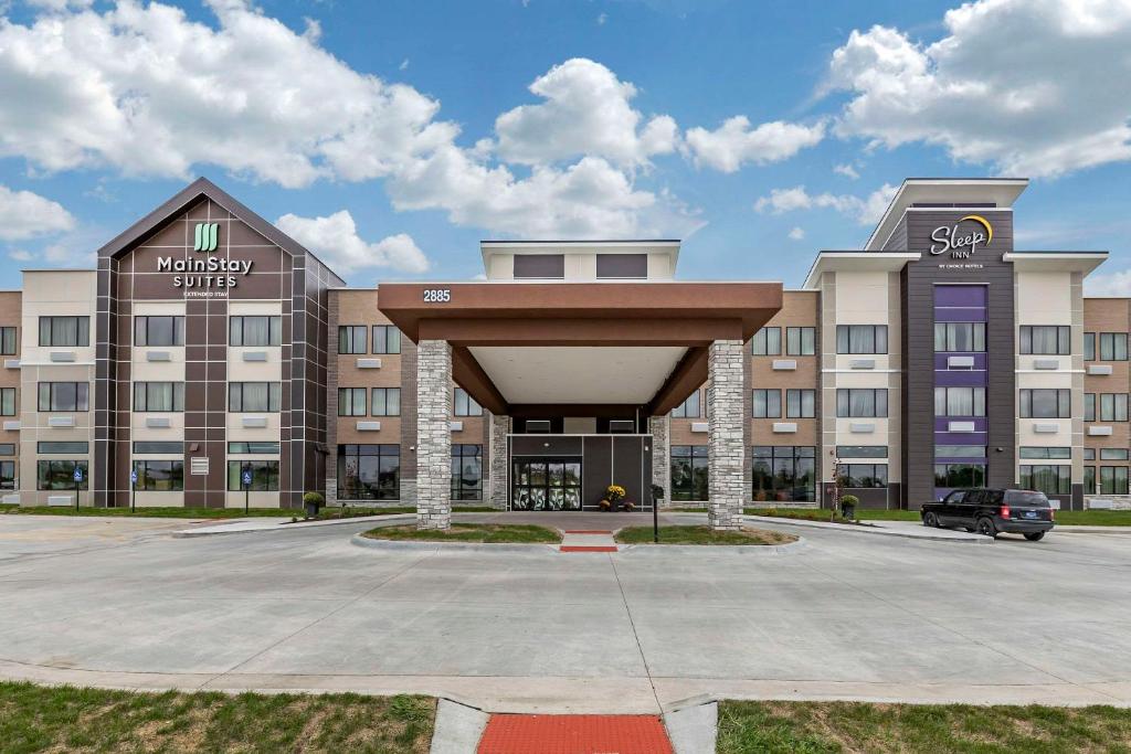 a large building with a parking lot in front of it at Sleep Inn & Suites Milwaukee-Franklin in Franklin