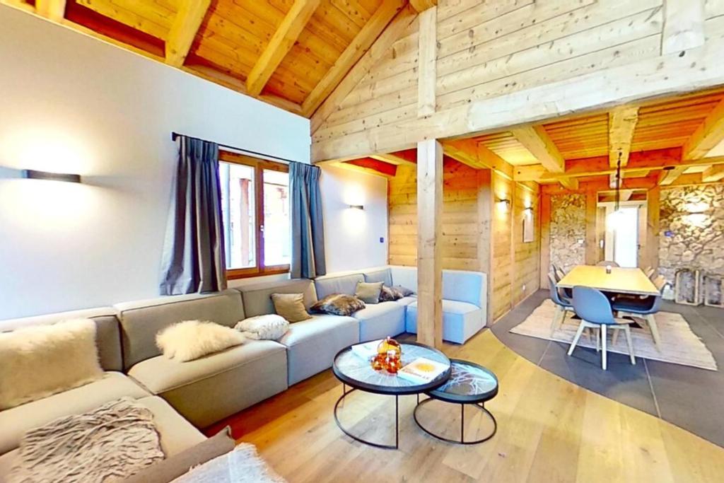 ein Wohnzimmer mit einem Sofa und einem Tisch in der Unterkunft CASA-Le Cherk Chalet 300m2 jacuzzi sauna Vars les Claux in Vars