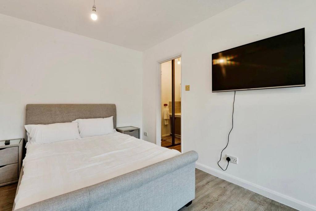 a bedroom with a bed and a flat screen tv on the wall at Remarkable 1-Bed Studio in Hayes in Hayes