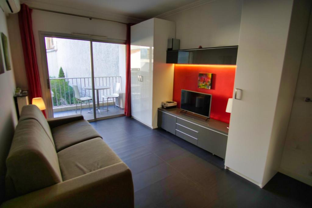 un salon avec un canapé et une télévision dans l'établissement Ref NAR - Palmes dProperties, à Cannes