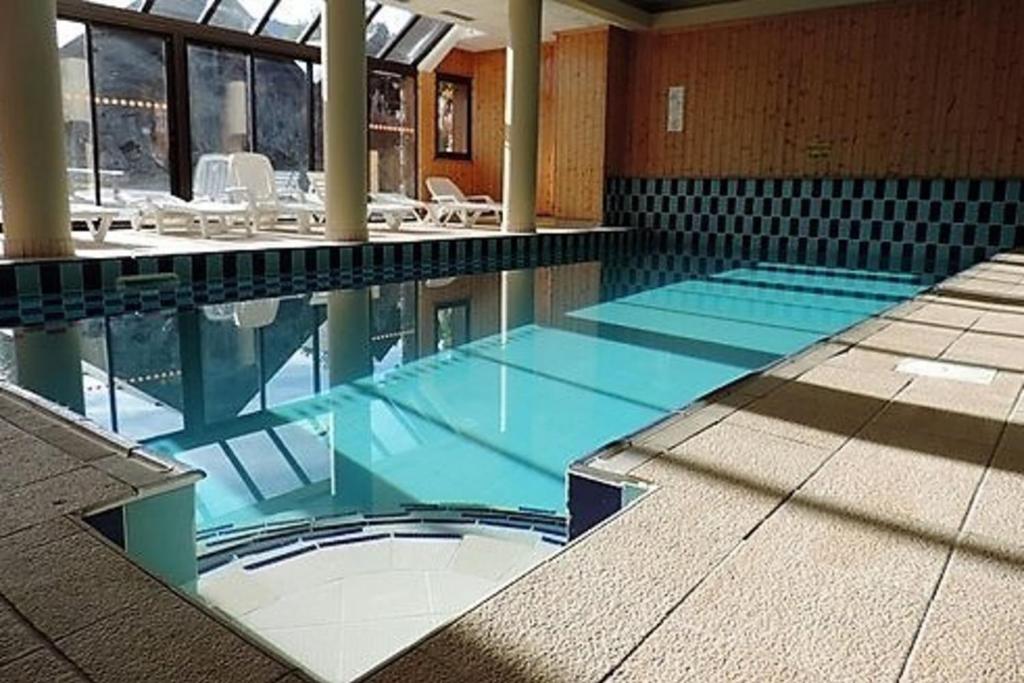 een groot zwembad met blauw water in een gebouw bij CASA-Sylvie 8p spa pool at the foot of the slopes in Risoul