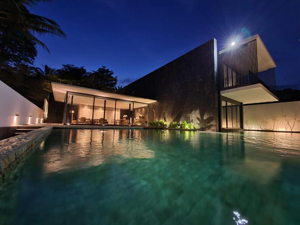 una casa con piscina por la noche en Beachfront 3 Bedrooms - AMANA Villa at Ta-Ke Residence Phuket, en Phuket