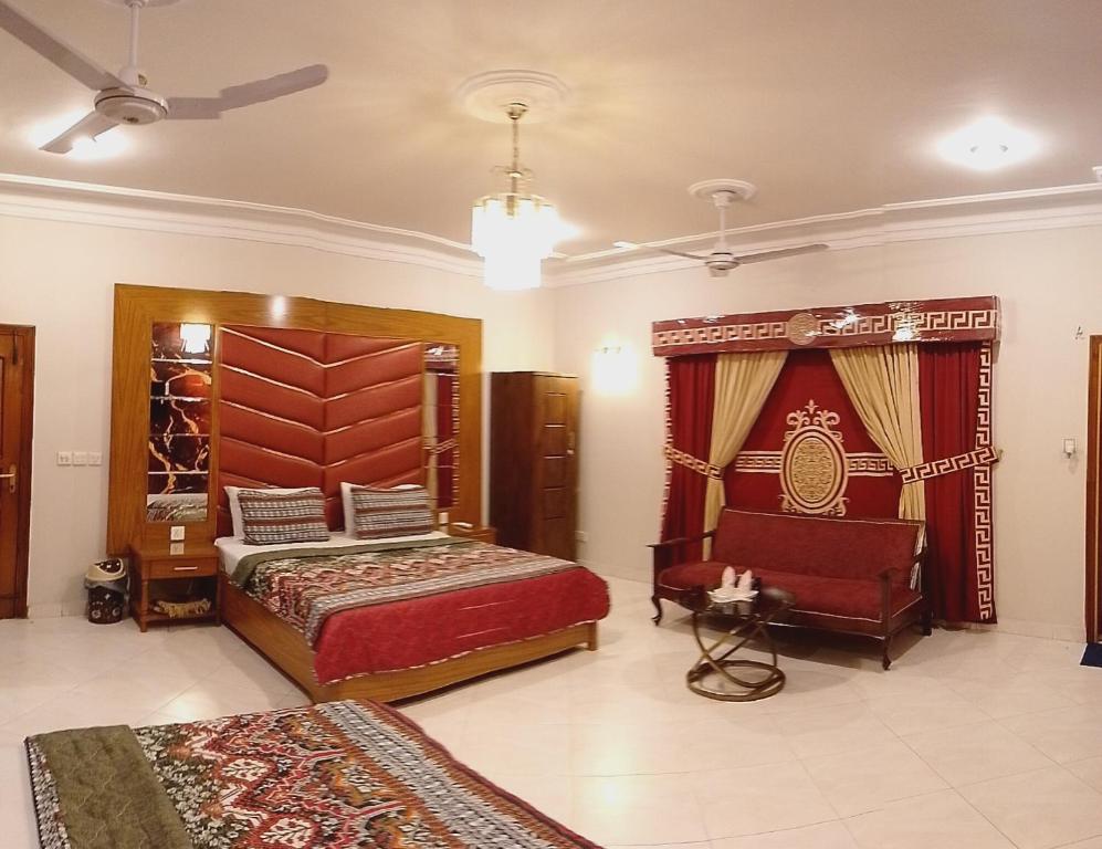 a large room with two beds and a chair at Travel lodge clifton in Karachi