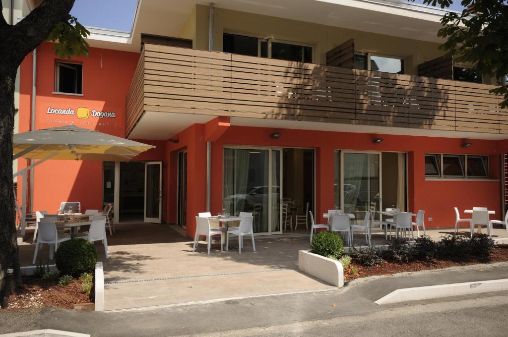 ペスキエーラ・デル・ガルダにあるLocanda Doganaの目の前にテーブルと椅子が置かれた建物