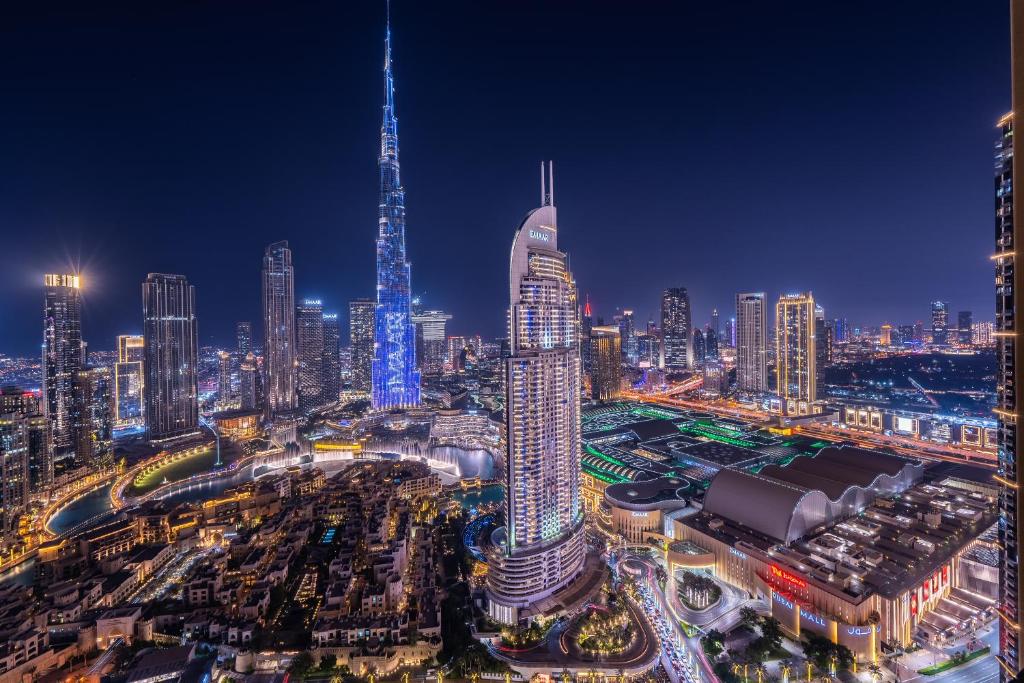 a city skyline at night with a tall skyscraper at Exquisite 2BR w/ Breathtaking Burj Khalifa Skyline in Dubai