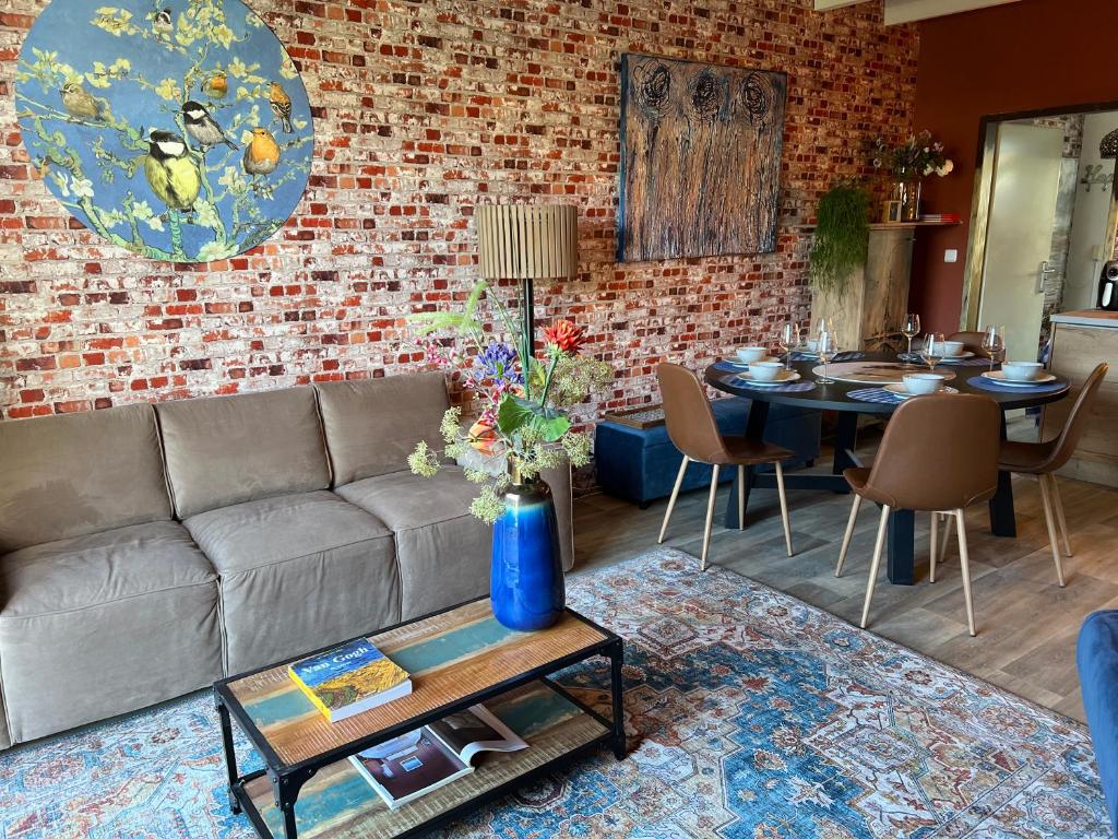 a living room with a couch and a table at Guesthouse by C in Colijnsplaat