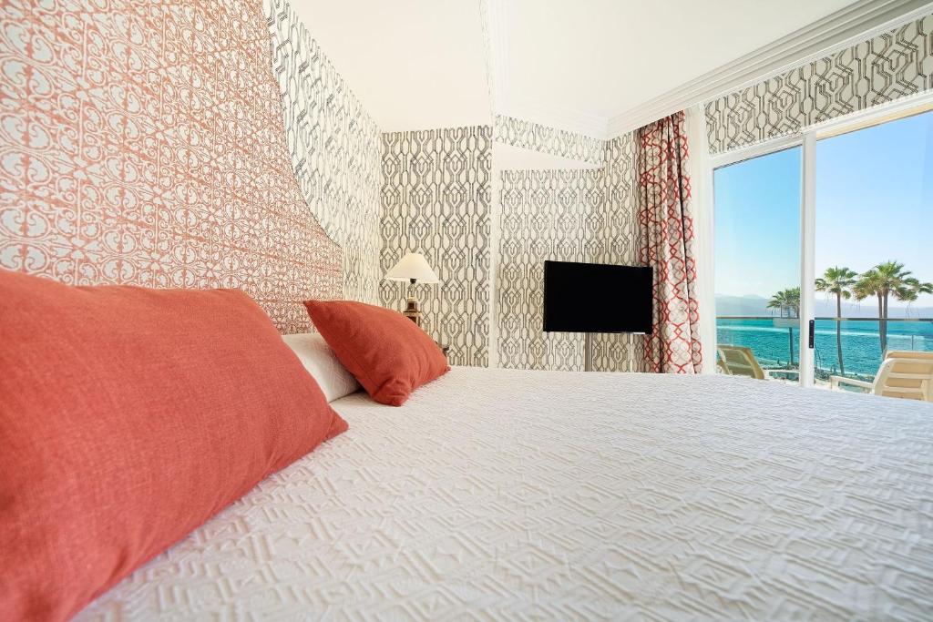 a bedroom with a large bed with a view of the ocean at Bull Reina Isabel & SPA in Las Palmas de Gran Canaria