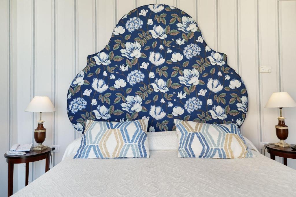 a bed with a blue and white floral headboard at Bull Reina Isabel & SPA in Las Palmas de Gran Canaria