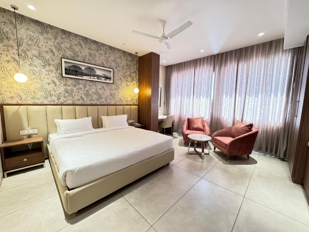 een hotelkamer met een bed en een stoel bij HOTEL CARNIVAL in Parbhani