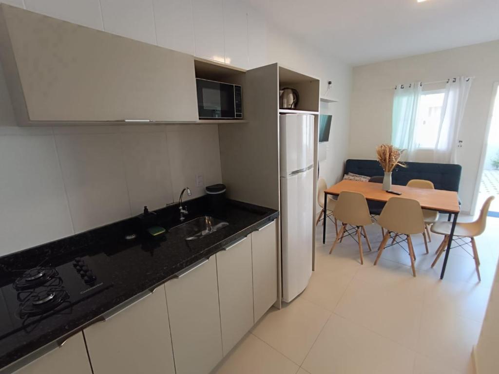een keuken en eetkamer met een tafel en een koelkast bij Residencial Brisa do Mar 2 in Bombinhas