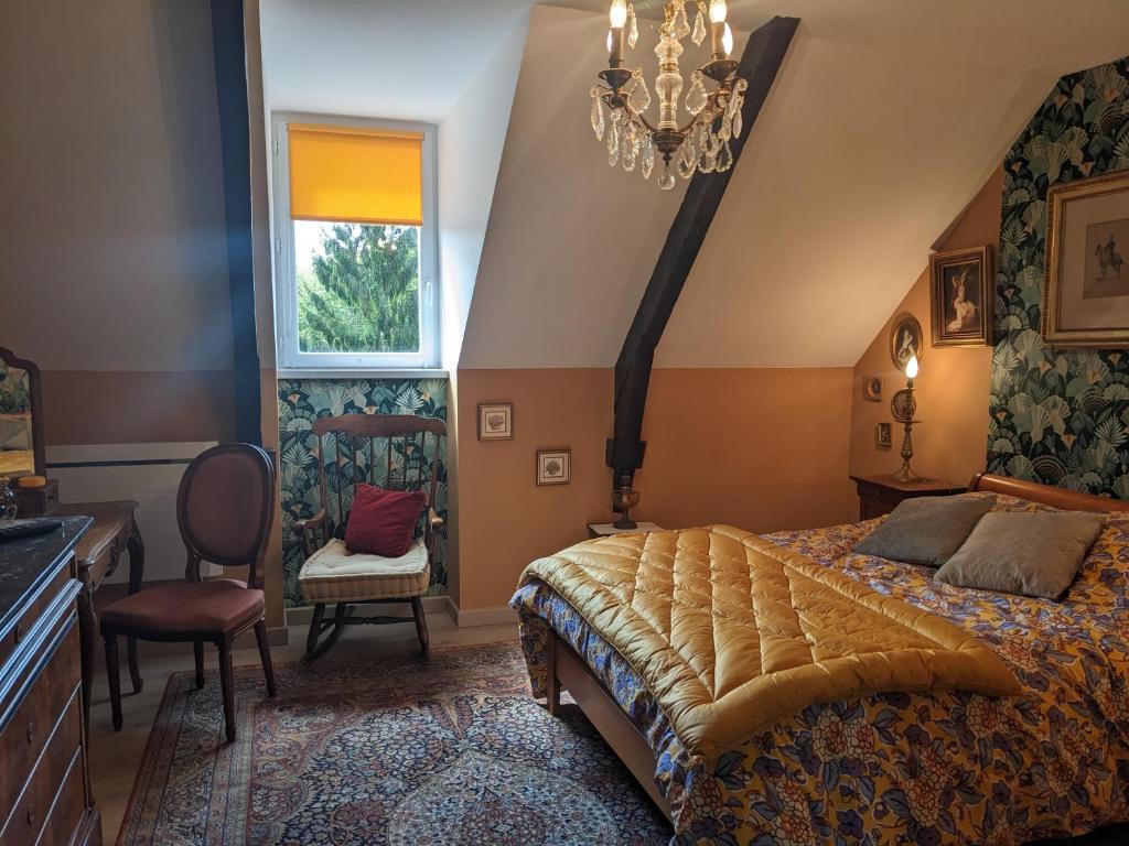 ein Schlafzimmer mit einem großen Bett und einem Kronleuchter in der Unterkunft Auberge des Trains Mythiques in Laniscat