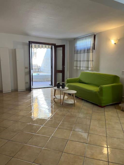 a living room with a green couch and a table at Casa Vacanze Padru in Padru