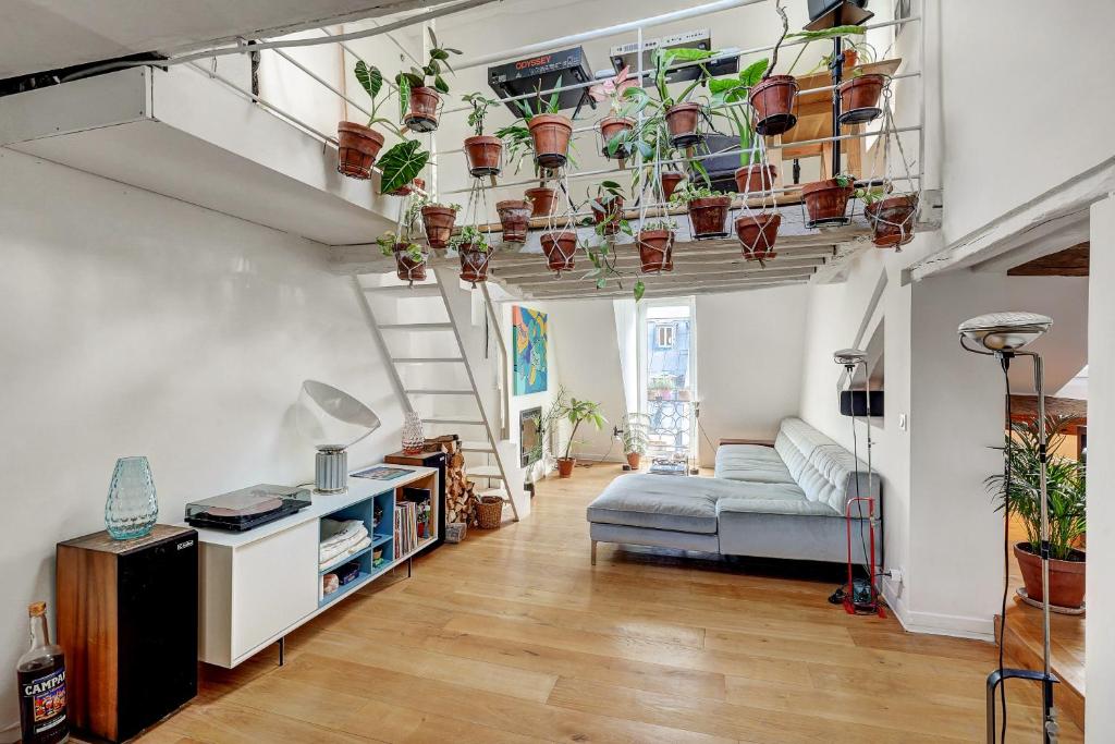 a living room filled with lots of potted plants at Pretty Parisian Penthouse in Paris