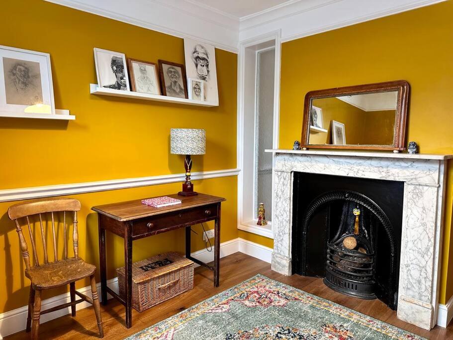 a room with a desk and a fireplace with a mirror at Cathedral Views Period Townhouse w/ Free Parking in Salisbury