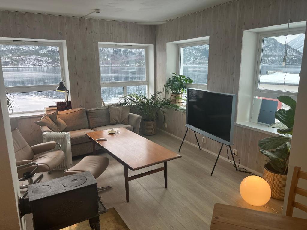a living room with a couch and a television at Ved sjøkanten, Ålesundsvegen 1068 in Ålesund