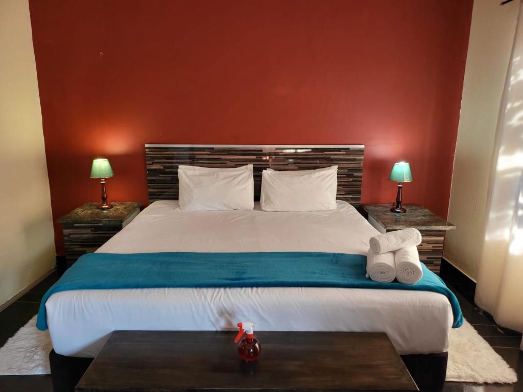 a bedroom with a large bed with two lamps at Gem of Manor drive in Durban