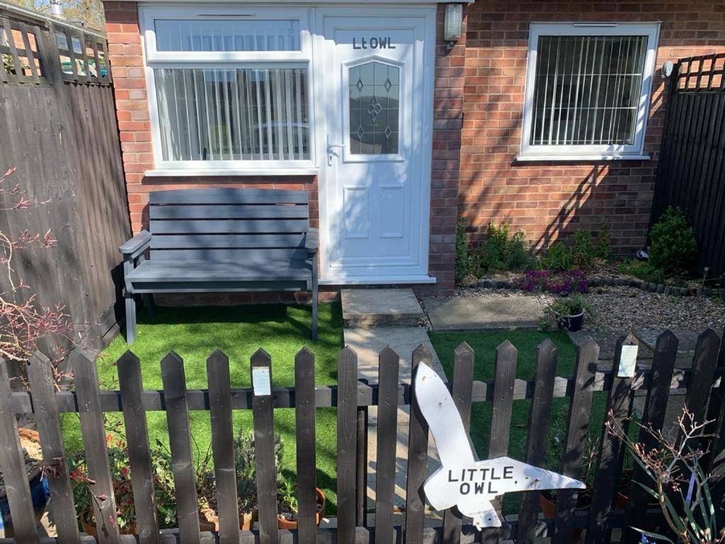 a fence with a little one sign in front of a house at Little Owl Self Catering in Little Barningham