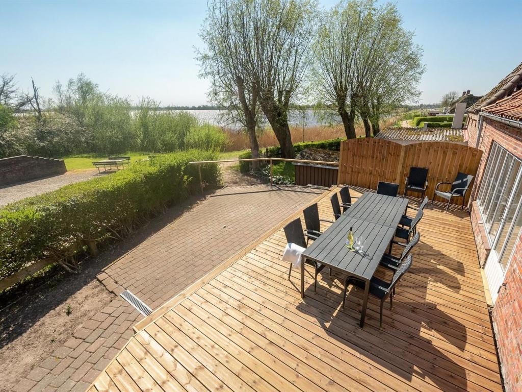 une terrasse en bois avec un banc et des chaises. dans l'établissement Holiday Home Gabija - all inclusive - in Western Jutland by Interhome, à Højer