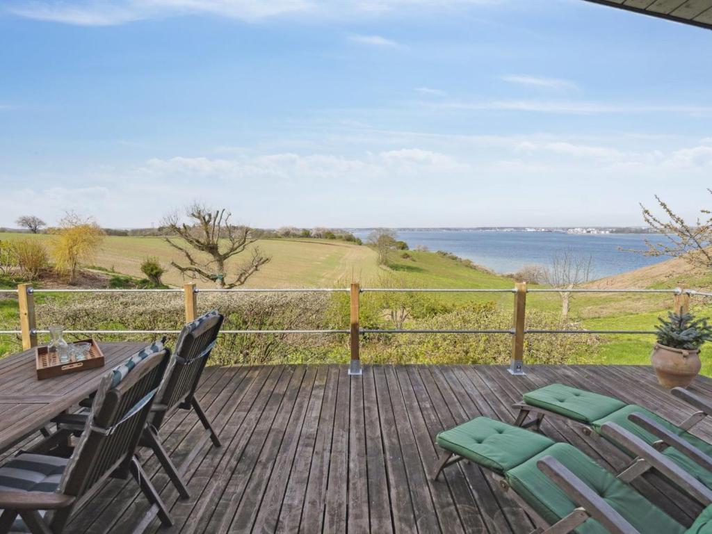 una terraza con mesa y sillas y vistas al agua en Holiday Home Geeske - 150m from the sea in Funen by Interhome, en Middelfart