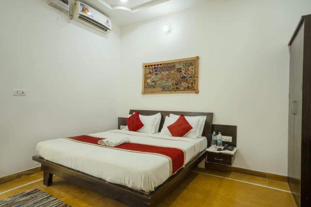 - une chambre avec un grand lit et des oreillers rouges dans l'établissement Deluxe gujrat hotel, à Jaisalmer