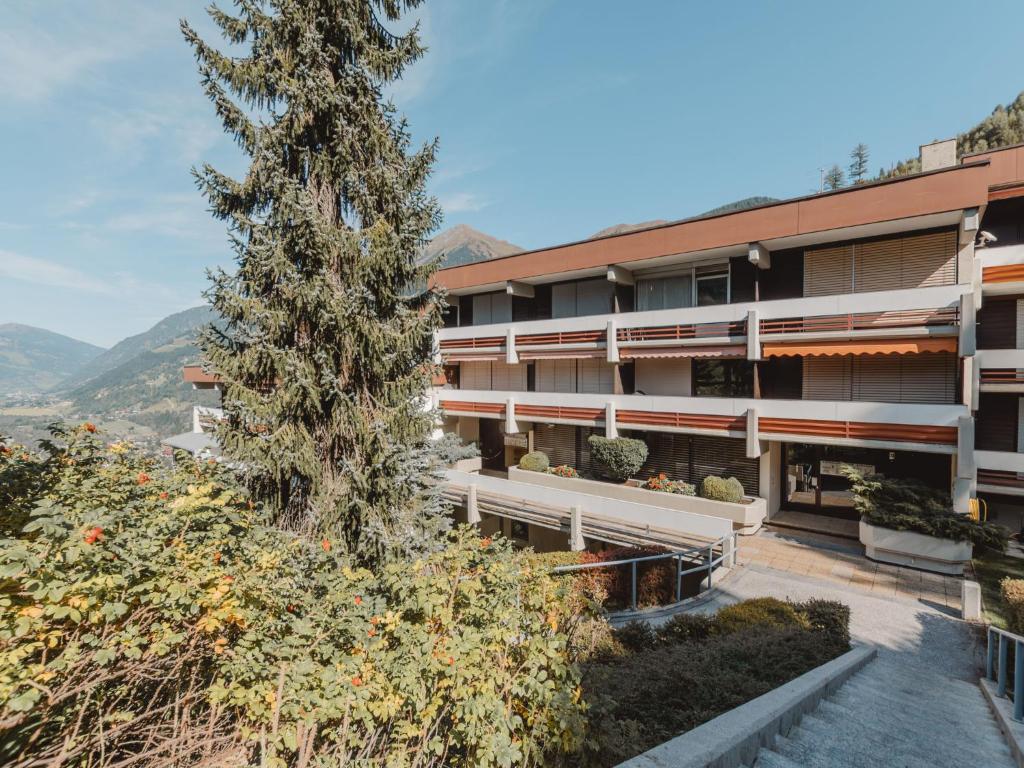 an apartment building with a tree in front of it at Apartment Alpenpanorama by Interhome in Bad Gastein