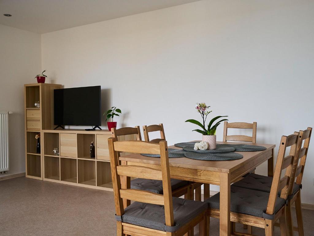 a dining room table with chairs and a television at Apartment U Dzina-2 by Interhome in Polubný