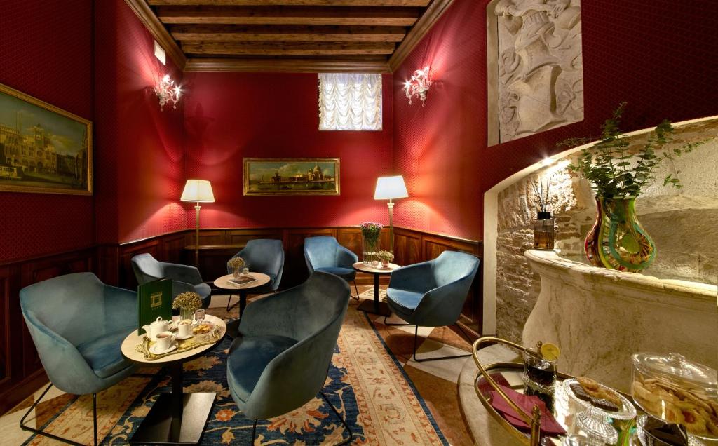 restauracja z czerwonymi ścianami oraz niebieskimi krzesłami i stołami w obiekcie Duodo Palace w Wenecji