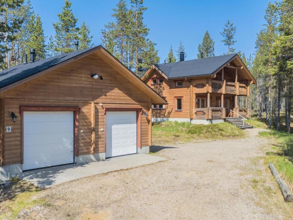 a log home with a garage in front of it at Holiday Home Koparanperä by Interhome in Kakslauttanen