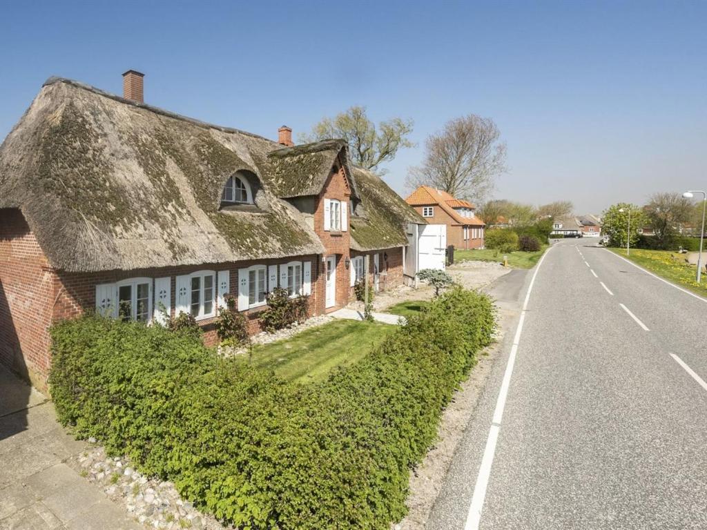 una casa con techo de paja al lado de una carretera en Holiday Home Evie - all inclusive - in Western Jutland by Interhome en Højer
