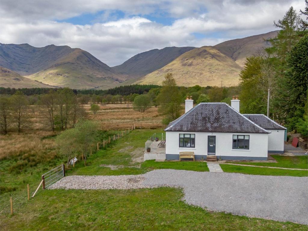 a house in a field with mountains in the background at 2 Bed in Dalmally CA379 in Dalmally