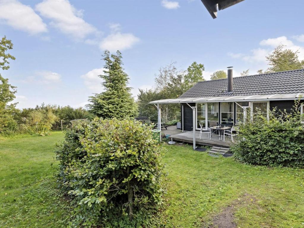 ein Haus mit einer Veranda und einem Hof in der Unterkunft Holiday Home Thorid - 850m from the sea in Sealand by Interhome in Fårevejle