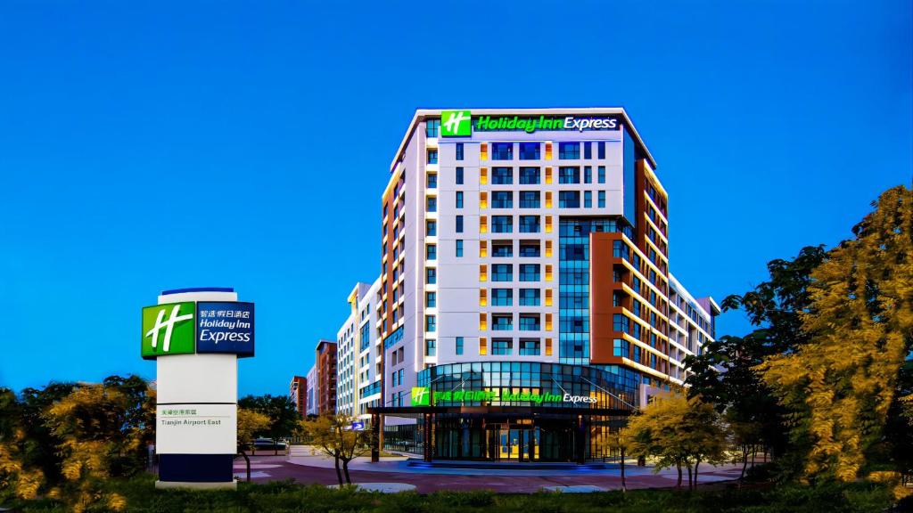 a tall white building with a sign on it at Holiday Inn Express Tianjin Airport East, an IHG Hotel in Tianjin