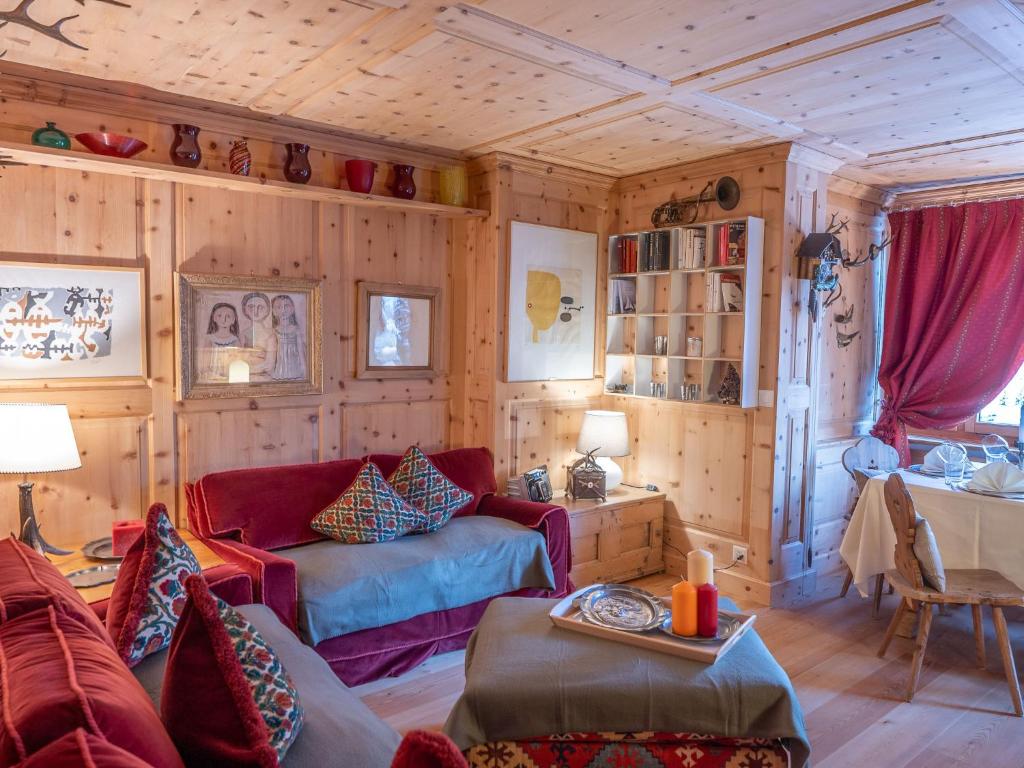 a living room with wooden walls and a red couch at Apartment Chesa Arlas C4 by Interhome in St. Moritz