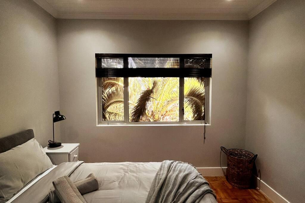 a bedroom with a bed and a window at Embassy Apartment in Cape Town