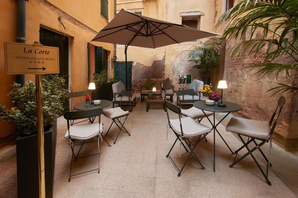 restauracja ze stołami, krzesłami i parasolem w obiekcie Duodo Palace w Wenecji