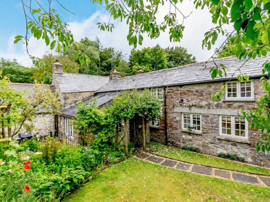 an old stone cottage with a garden in front of it at 3 Bed in Polyphant 78210 in Trewen