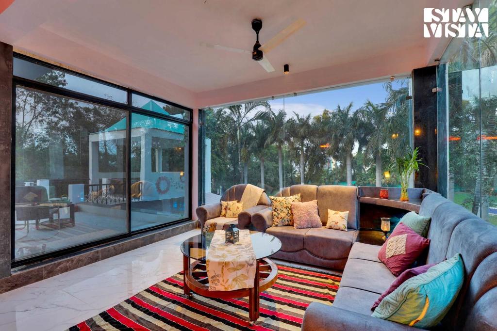 - un salon avec un canapé et une table dans l'établissement StayVista's Palm Perle Villa - Pet-Friendly Retreat with Terrace, Lawn & Pool Table, à Bhopal