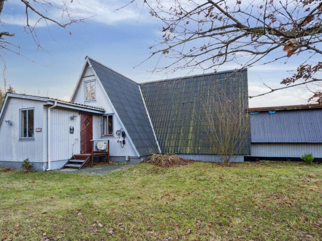 una casa blanca con techo gris en Holiday Home Kierulf - 6-6km from the sea in Djursland and Mols by Interhome en Ebeltoft