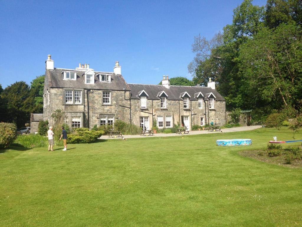 una casa vieja con gente parada frente a ella en Creebridge House Hotel en Newton Stewart