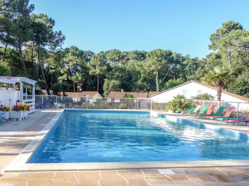 una piscina con una valla y árboles en el fondo en Holiday Home Bois d'Eleis-3 by Interhome, en Les Mathes