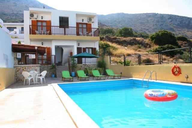 a swimming pool in front of a house at Elgoni Apartments in Hersonissos