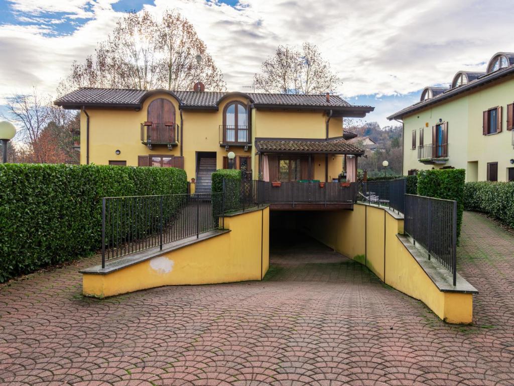 Apartment Lagoni by Interhome في أرونا: منزل اصفر كبير وبه ممشى يؤدي اليه