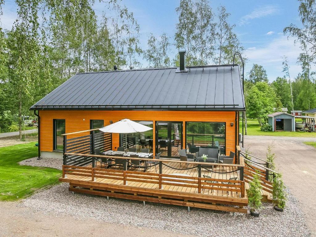 a tiny house with a table and an umbrella at Holiday Home Lukupirtti by Interhome in Säkylä