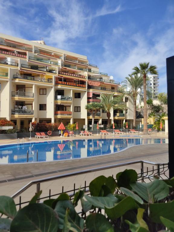 a hotel with a swimming pool in front of a building at Apartamento en Los Cristianos Edificio Guayero in Los Cristianos