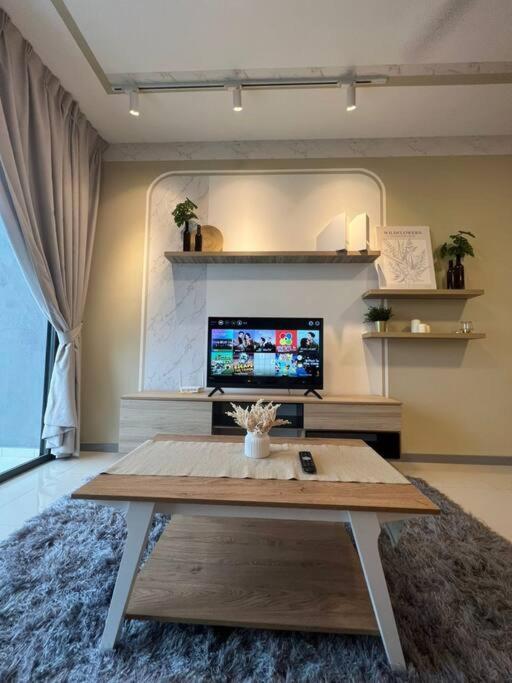 a living room with a coffee table and a tv at Idyllic Cottage 3BR Desa Park City Mont Kiara in Kuala Lumpur